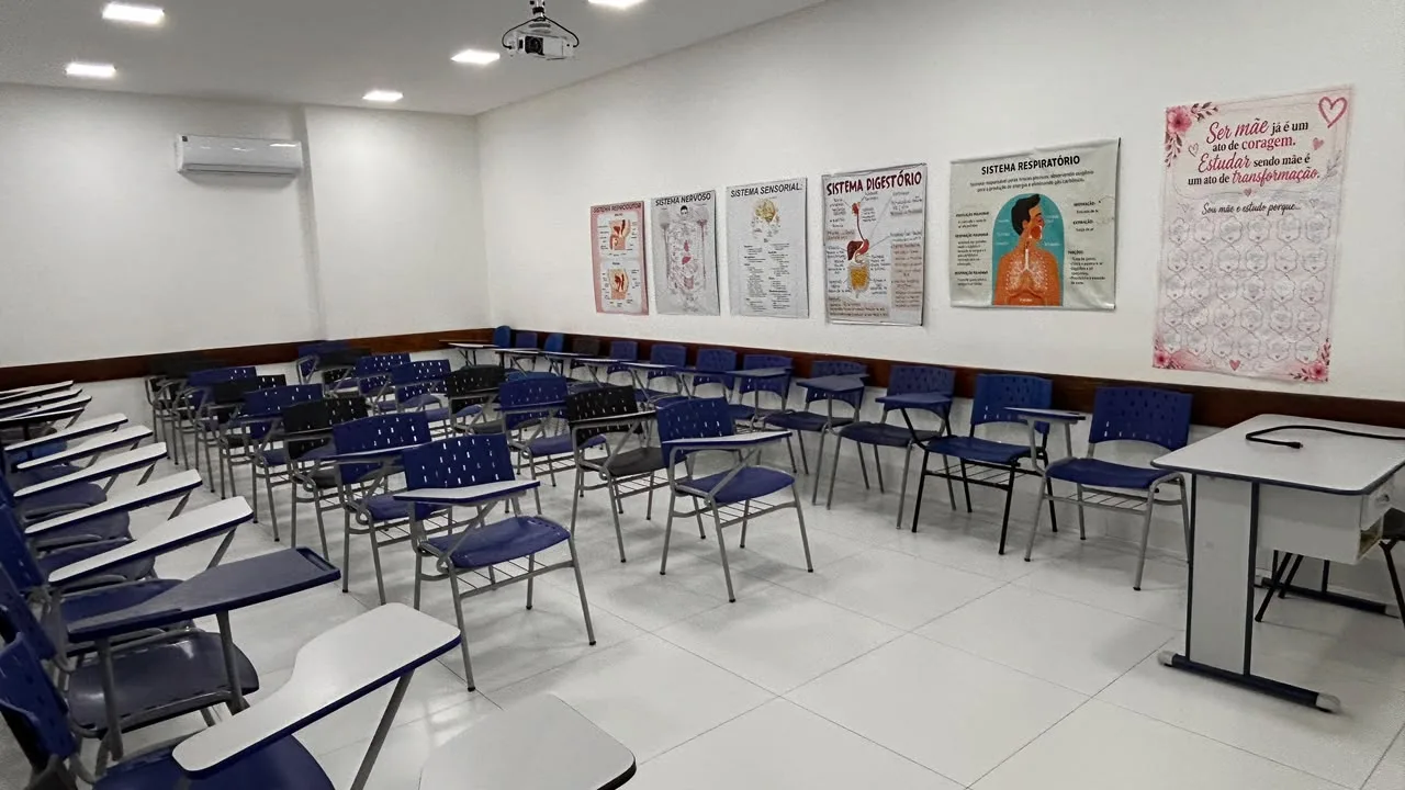 Sala de aula ampla com paineis dos sistemas do corpo humano e projetor no teto