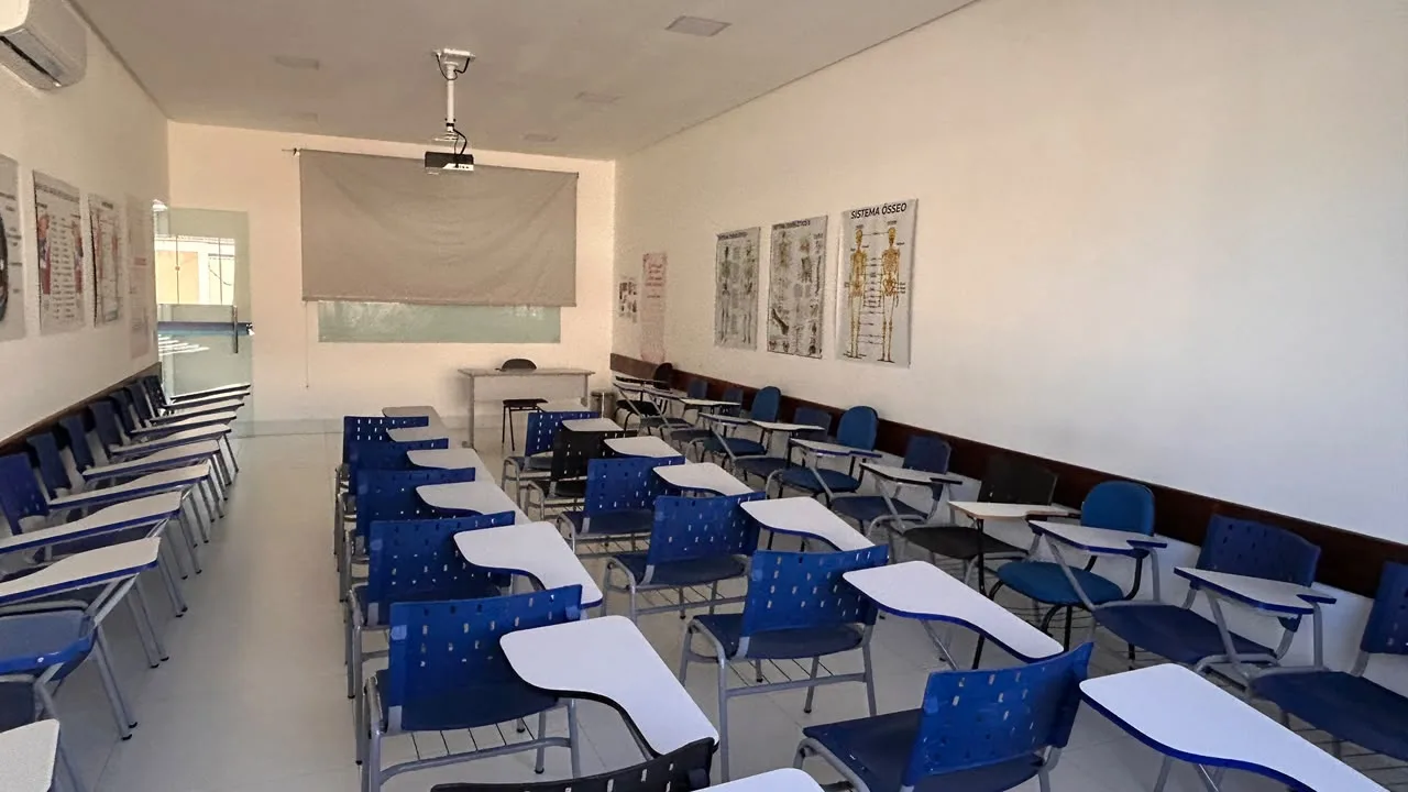 Sala de aula com projetor, tela de projecao e paineis de anatomia