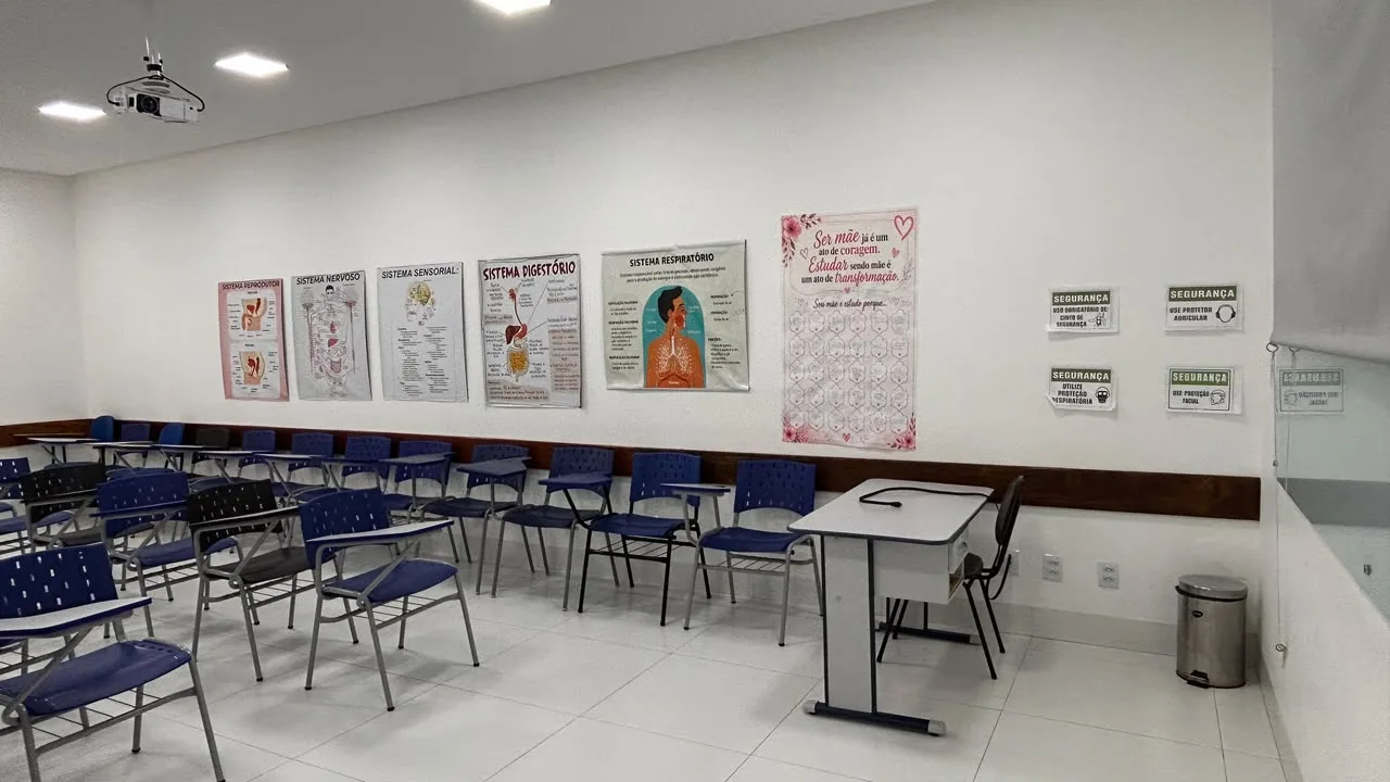 Sala de aula com paineis de anatomia e placas de seguranca do trabalho e uso de EPI