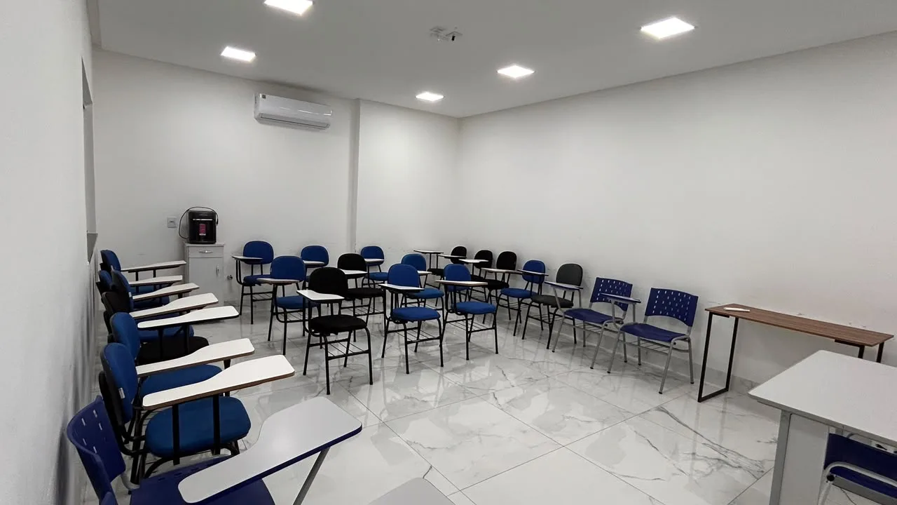 Sala de aula climatizada com carteiras universitarias e piso porcelanato