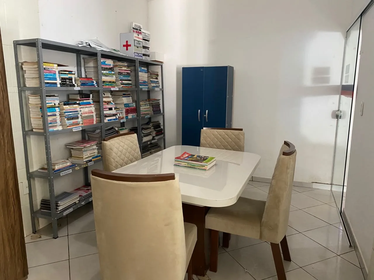 Biblioteca com estantes de livros organizados por area e mesa de estudos